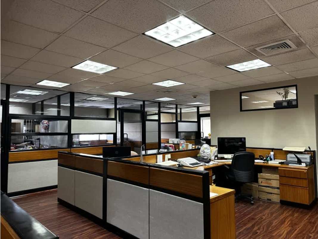 Traditional office interior with multiple cubicles, glass partitions, and lighting Scotia Plaza Panama