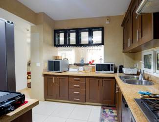 Living room with chandelier, glass doors to balcony, and garden view at PH Tucan Arraiján Panama