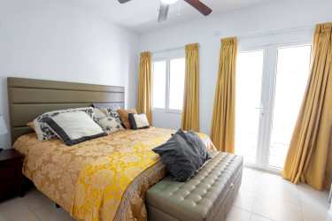 Bedroom with upholstered headboard, dining nook, and tile floors at PH Tucan Panama Pacifico