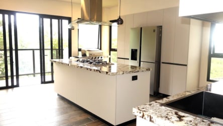 Open plan living dining room with large windows and mountain landscape views Altos del María Panama