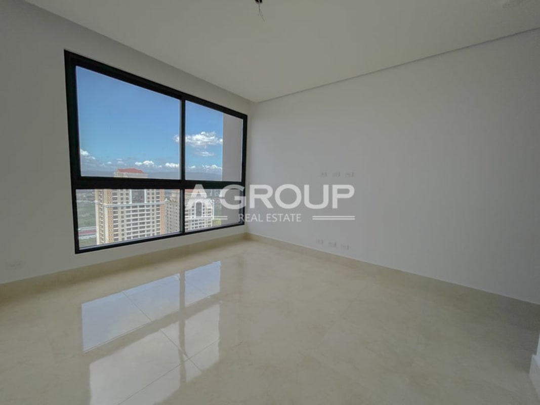 Empty modern bedroom with floor to ceiling window offering city view Costa del Este