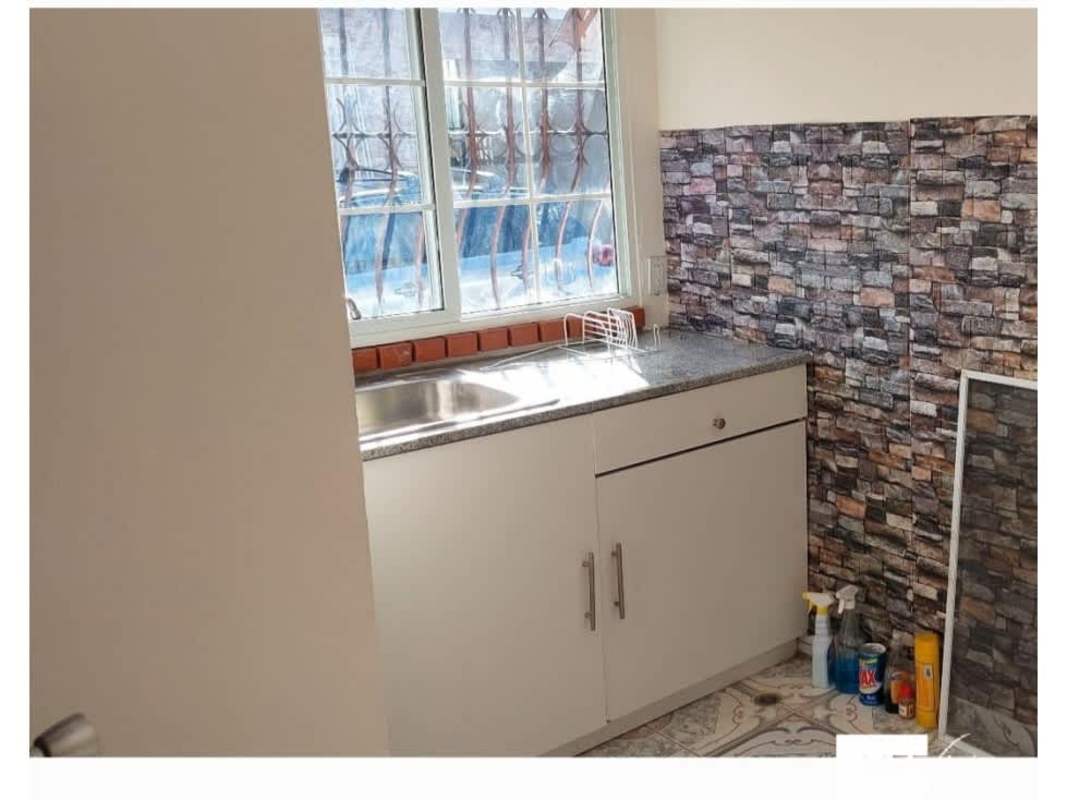 Compact kitchen with faux brick backsplash natural light Don Bosco Panama
