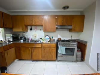 Kitchen with wooden cabinetry granite counters stainless steel appliances in Howard Panama Pacifico