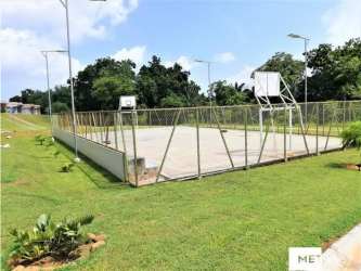 Outdoor playground with swings and slide surrounded by grass and homes PH La Campiña Panama