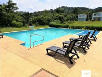Swimming pool with lounge chairs, greenery and mountain view at PH La Campiña Panama