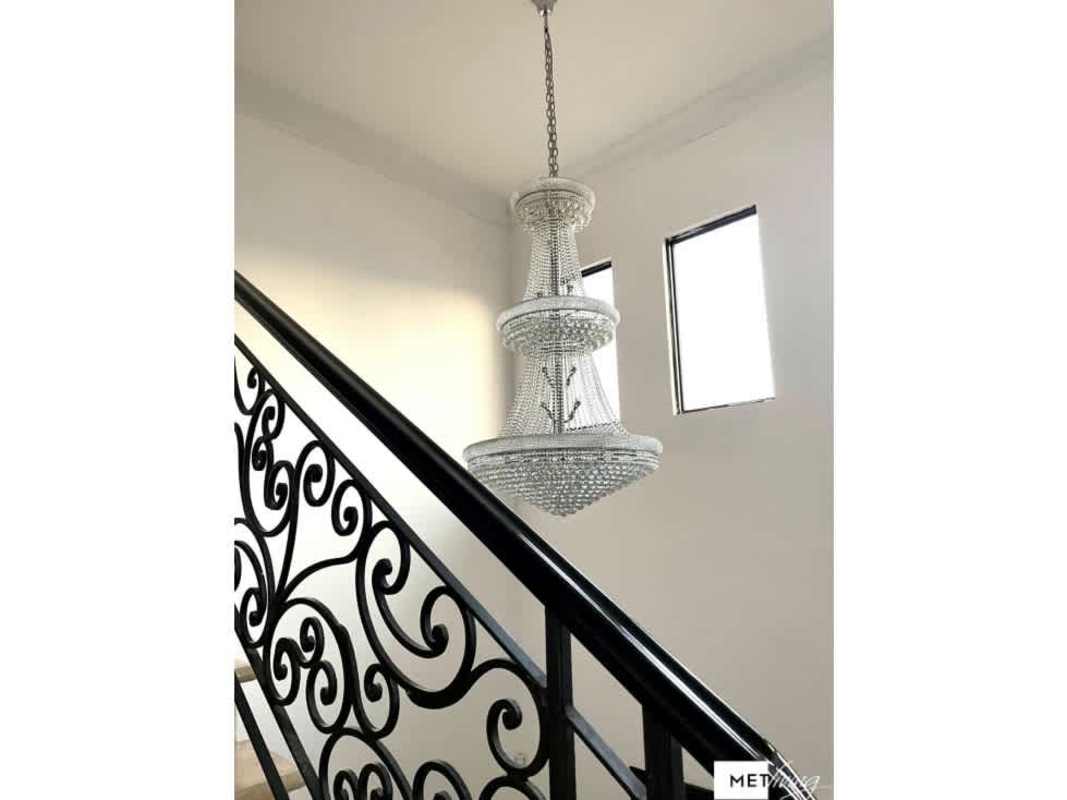 Elegant staircase with wrought iron railing and chandelier in Mediterranean home Costa del Este Panama