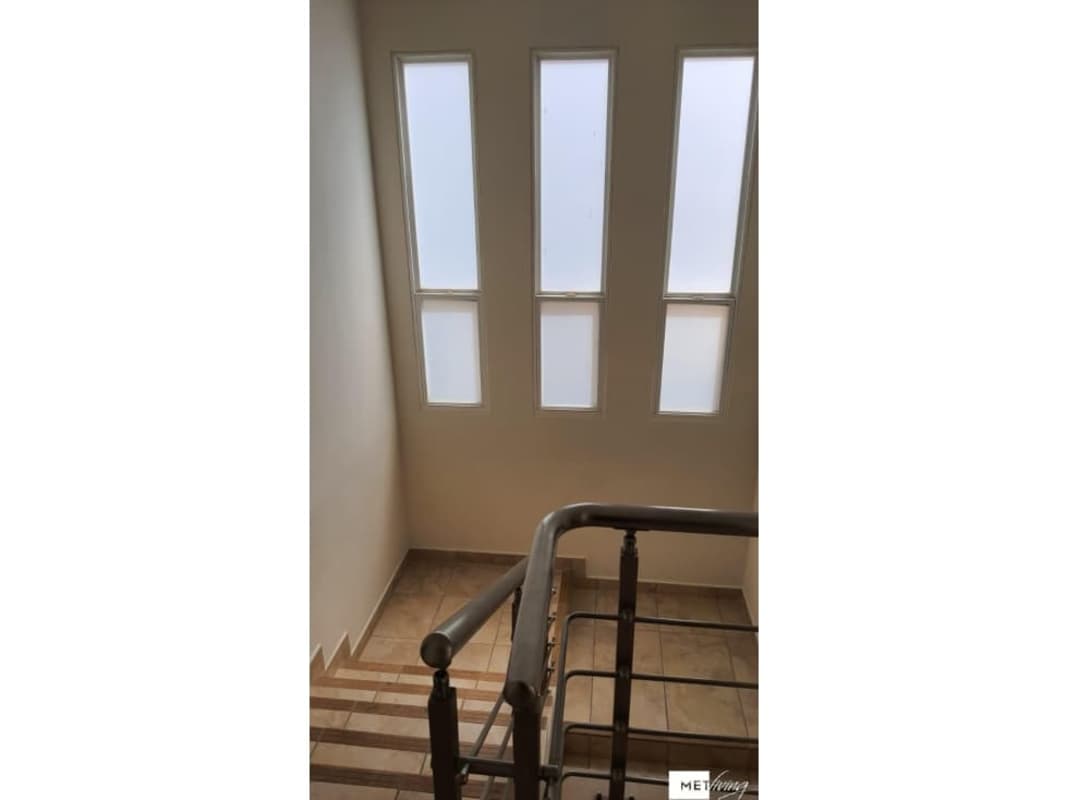 Interior staircase with tall frosted windows metal railing PH Everest Brisas del Golf