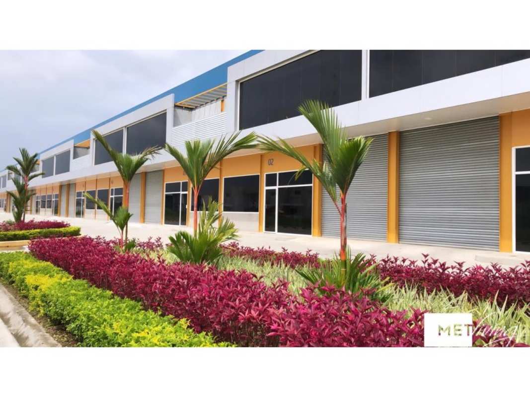 Commercial warehouse complex entrance with landscaped gardens, palm trees, ample parking, multiple garage doors Panama City