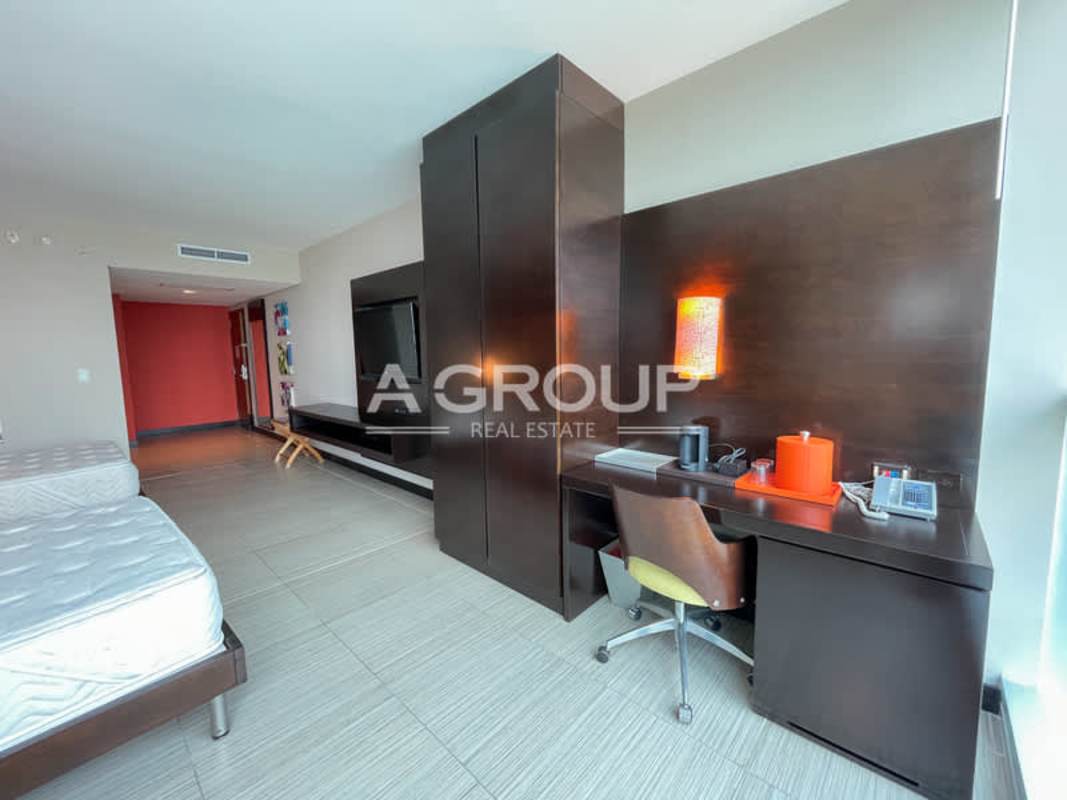 Suite bedroom featuring built-in desk, mounted TV and twin beds at PH Megapolis Panama Marbella
