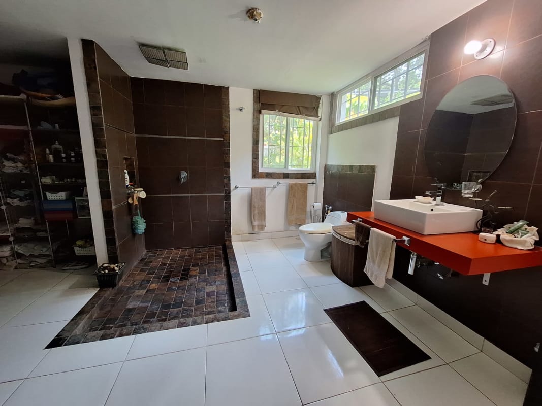 Bedroom with accent wall, bed, sofa, dining space Paraíso Ancón Panama