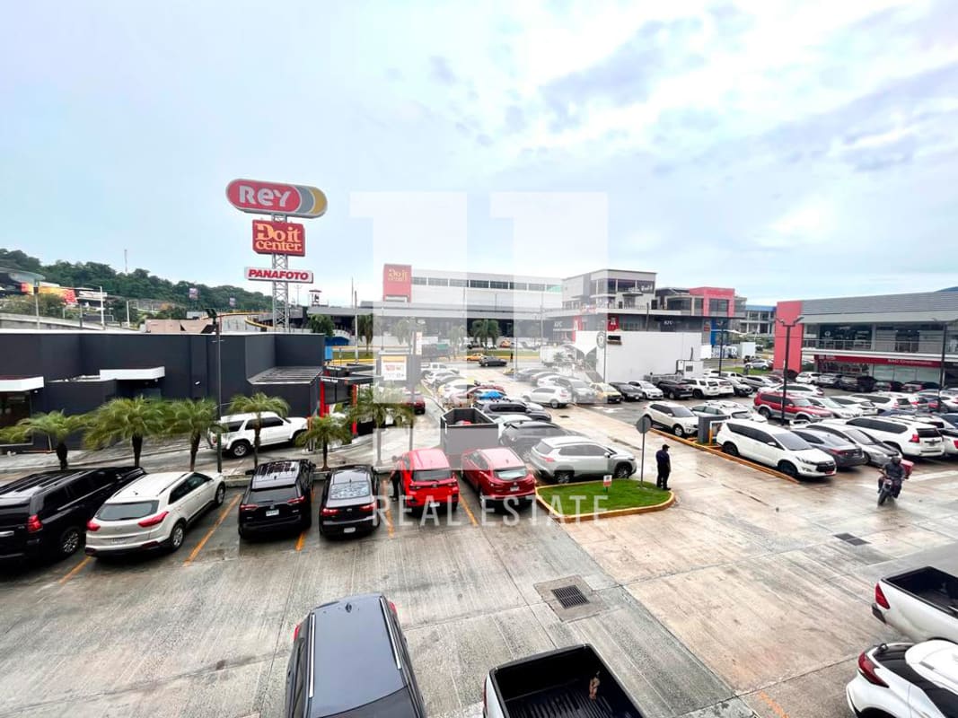 Commercial plaza exterior with large parking lot and storefront signage Condado del Rey Panama