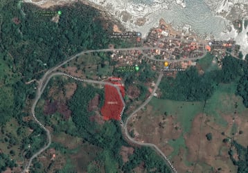 Paved access road with tropical trees leading towards beachfront land for sale in Viento Frio Costa Arriba Panama