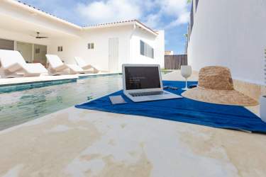 Infinity swimming pool with lounge chairs and palm trees at Paradise Point Coronado Panama
