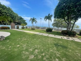 Open living and dining space with large windows and sea views at PH Miramar Farallon Panama