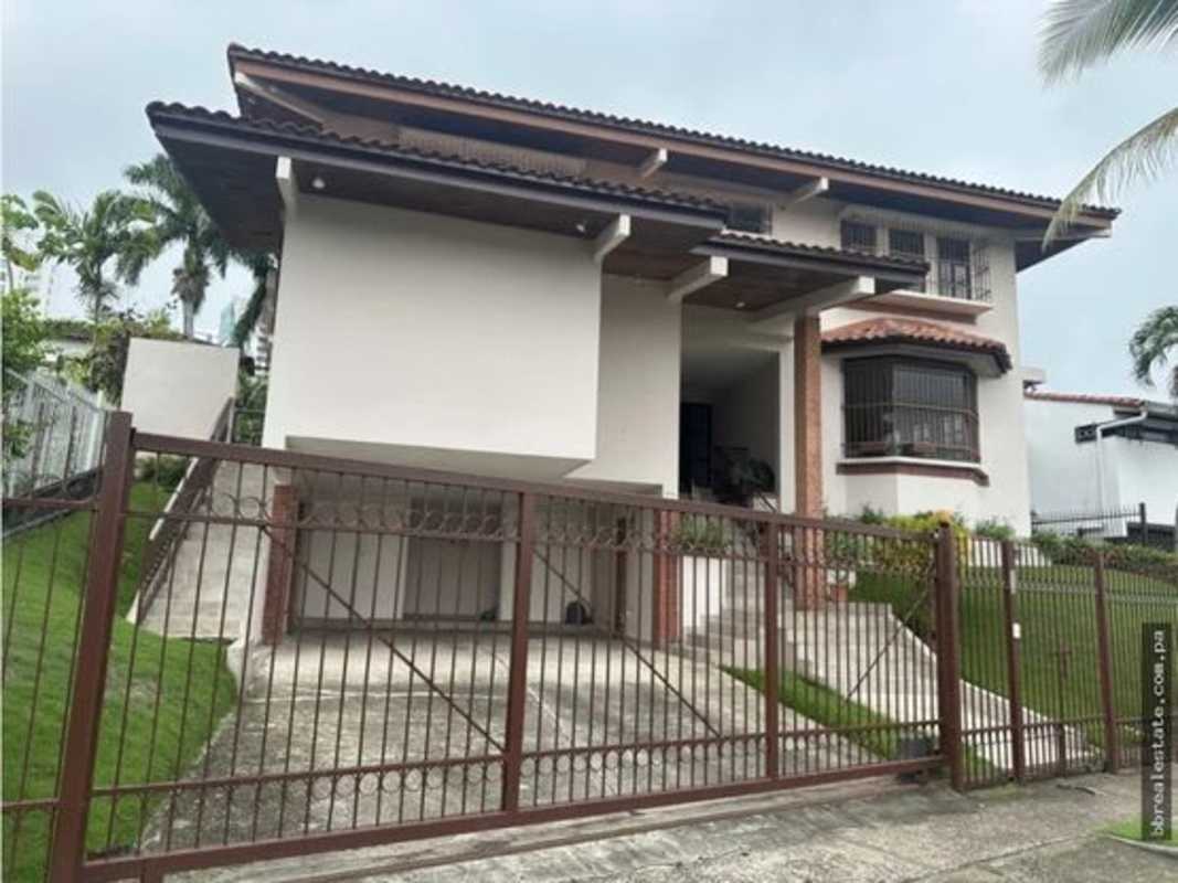 Two-story Mediterranean house facade with tile roof and bay window in Altos del Golf Panama