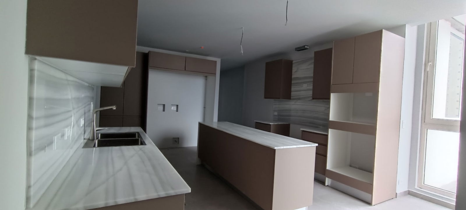 Luxury bathroom with marble walls, dual sinks, round mirrors at The Towers Punta Paitilla Panama