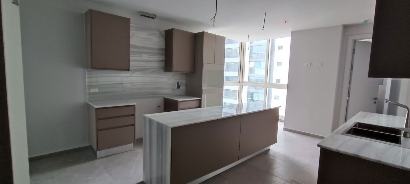 Spacious kitchen with marble counters, island, large windows at The Towers Punta Paitilla Panama