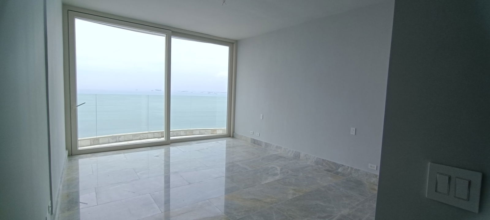 Luxury empty room with glass doors opening to oceanfront balcony The Towers Punta Paitilla Panama