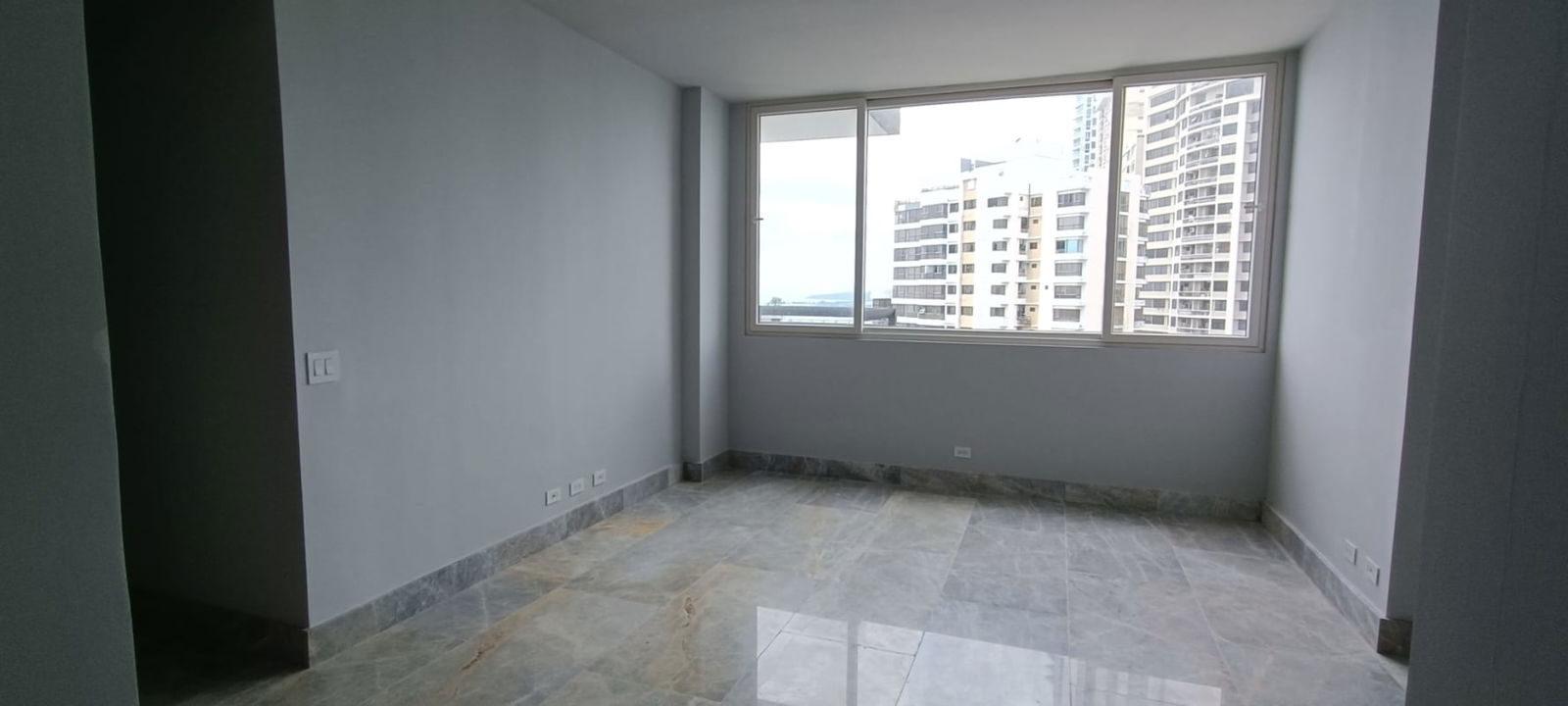 Spacious living room marble floors large window Panama skyline The Towers Punta Paitilla