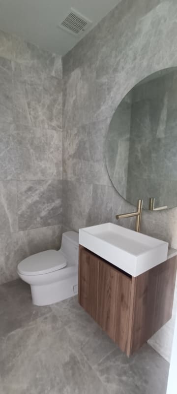 Luxury bathroom with marble walls, vessel sink, round mirror The Towers Punta Paitilla Panama