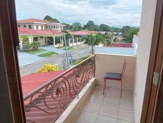 Living room with sectional sofa, TV, AC, and staircase Terronal David home Panama