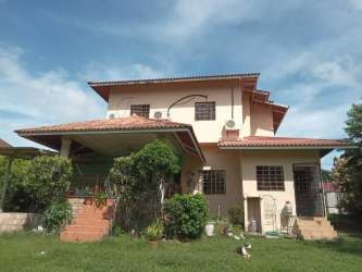 Two-story house red tiled roof surrounded by garden Terronal David Panama house for sale