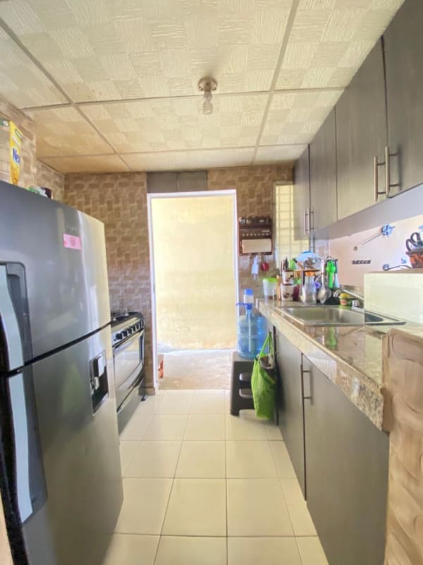 Compact kitchen with granite countertop, refrigerator, stove and tiled floors in Pacora house Los Jardines