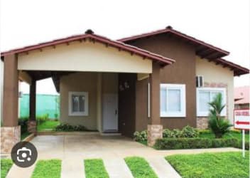 Bright kitchen area with cabinets, fridge, stove inside single-story house in Puerto Caimito La Chorrera Panama