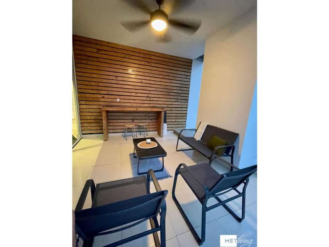 Modern enclosed terrace with lounge furniture and wood accent wall at Cosmopolitan San Francisco Panama