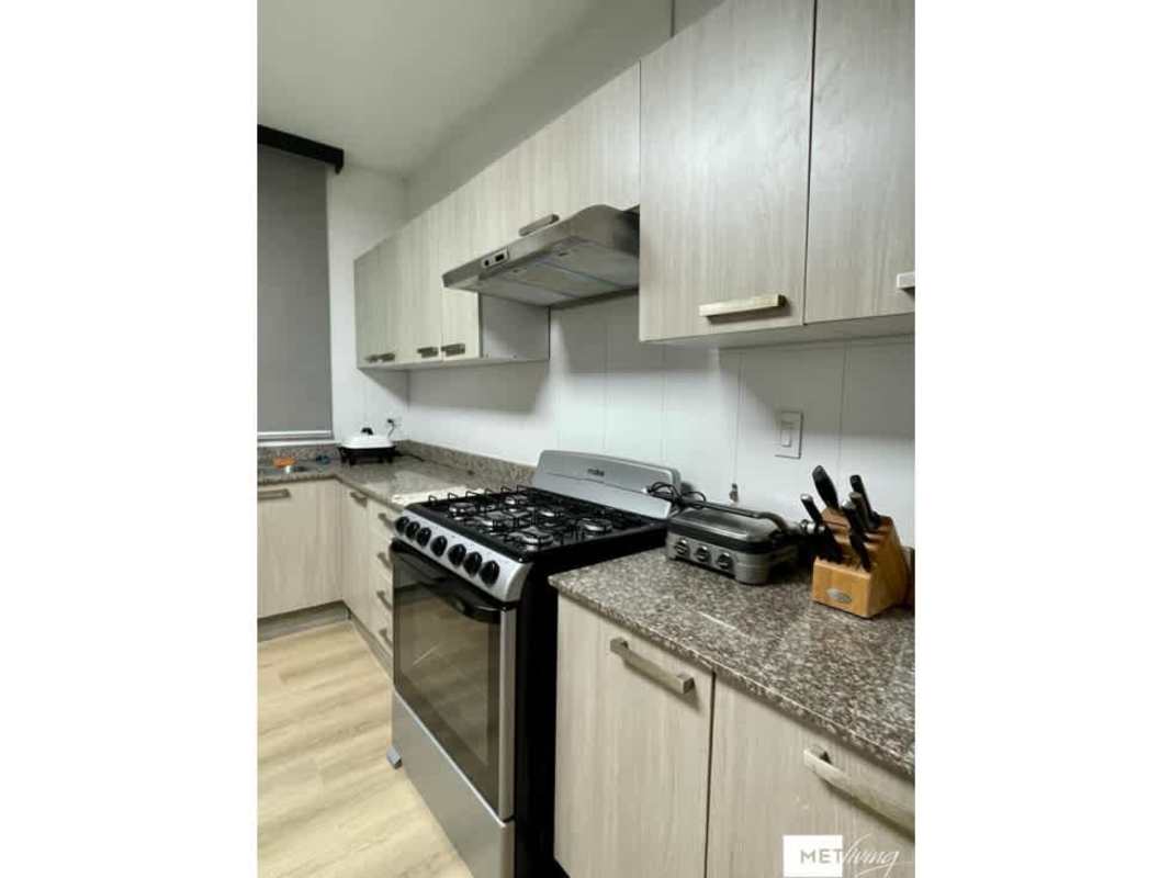 Kitchen featuring granite countertops, wood cabinetry, and modern appliances in PH Cosmopolitan San Francisco Panama