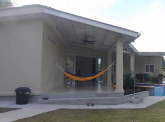 Covered outdoor dining patio with view of pool and garden in El Espino San Carlos Panama home