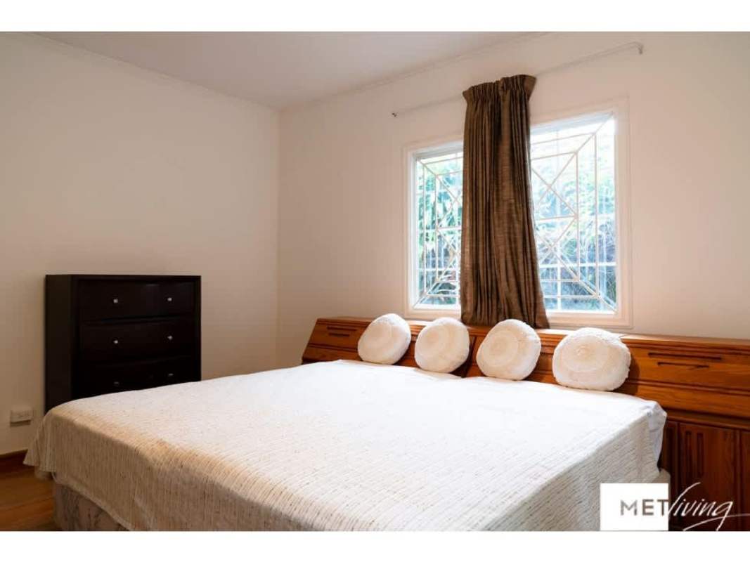 Bedroom with large bed, windows, round pillows and dresser in Obarrio property Panama City