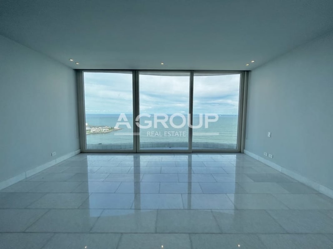 Spacious living room with curved floor-to-ceiling windows and Pacific Ocean view in The Towers Punta Paitilla apartment