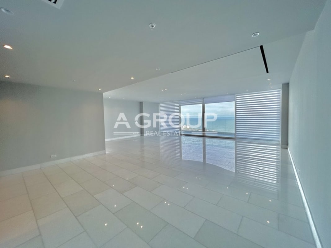 Modern open plan living dining room with curved windows and water views in The Towers Panama City