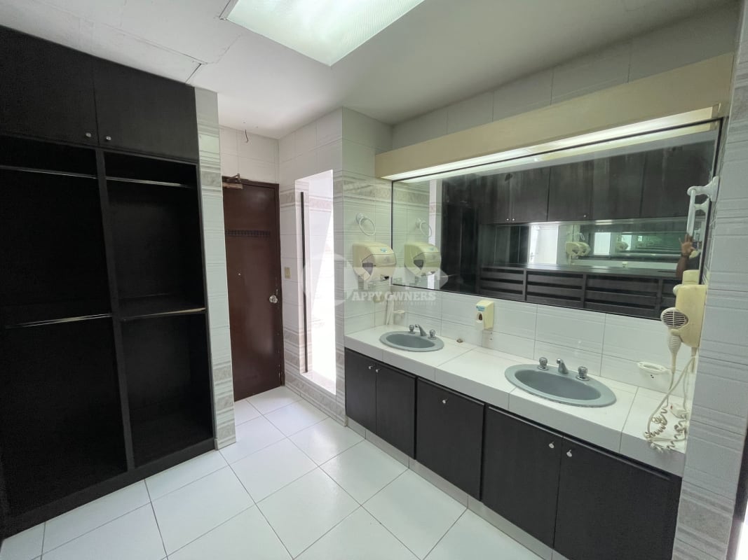 Modern sunroom with large windows, tiled floor, view of pool and tropical garden in Dos Mares Panama