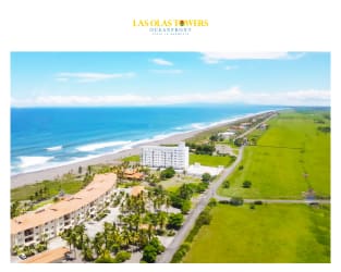 Beachfront high-rise condominium with pool and palm trees at Playa La Barqueta Panama