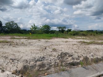 Gravel access road with sidewalks leading into gated Costa Esmeralda in San Carlos Panama