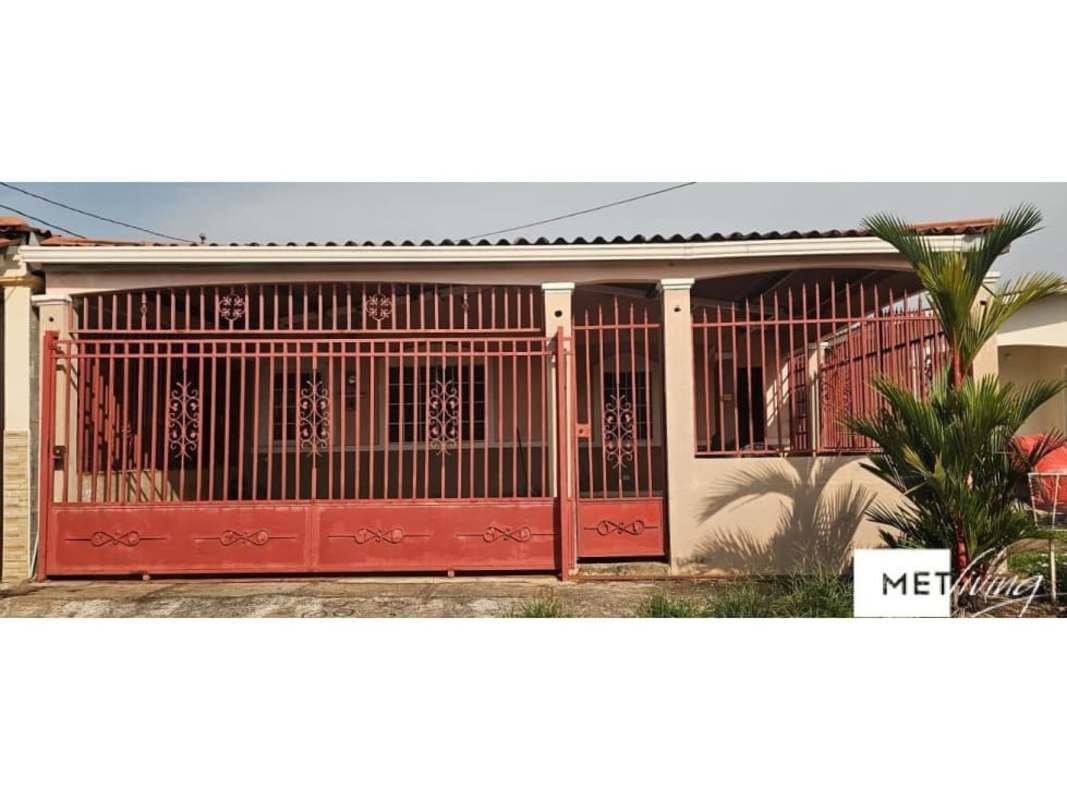 Exterior of one-story house with red metal fence and covered porch La Chorrera Panama