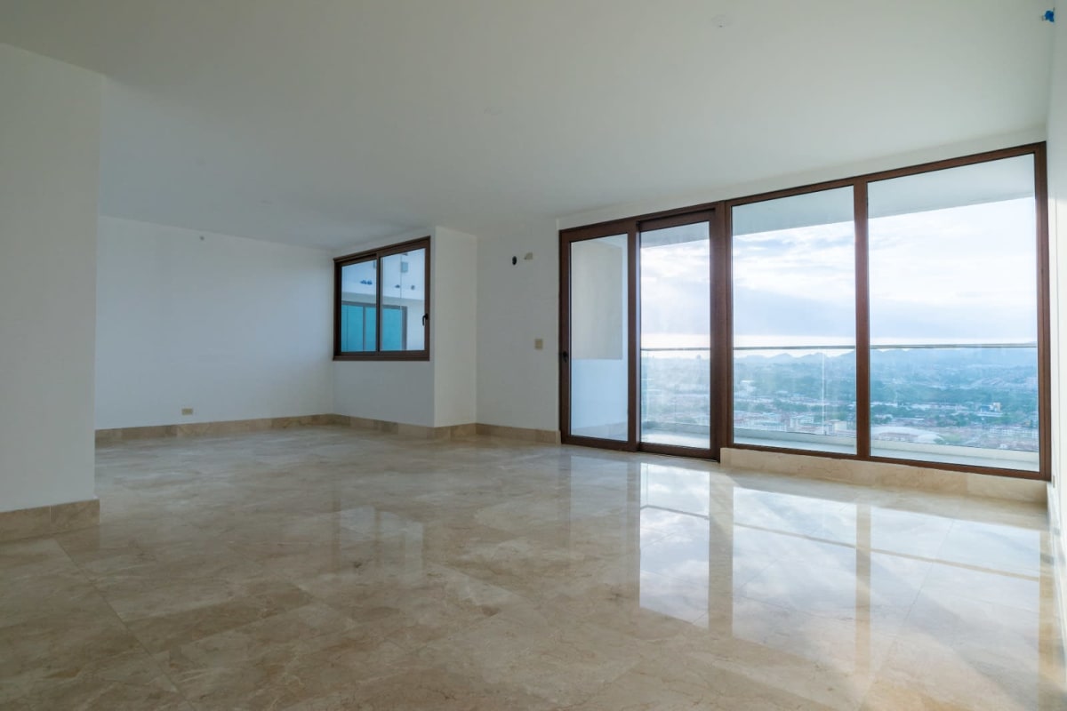 Large living room with marble floors and city view windows at The Colonial Santa Maria Panama