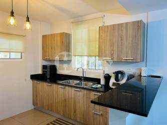 Kitchen with wood cabinetry black fridge oven Villas del Golf Panama