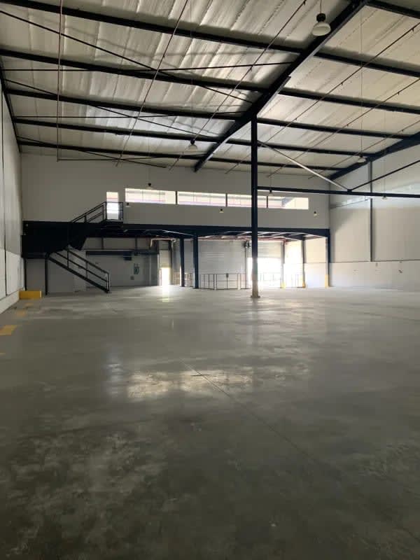 Spacious empty warehouse with high ceilings, mezzanine, industrial lighting in Las Mañanitas Panama