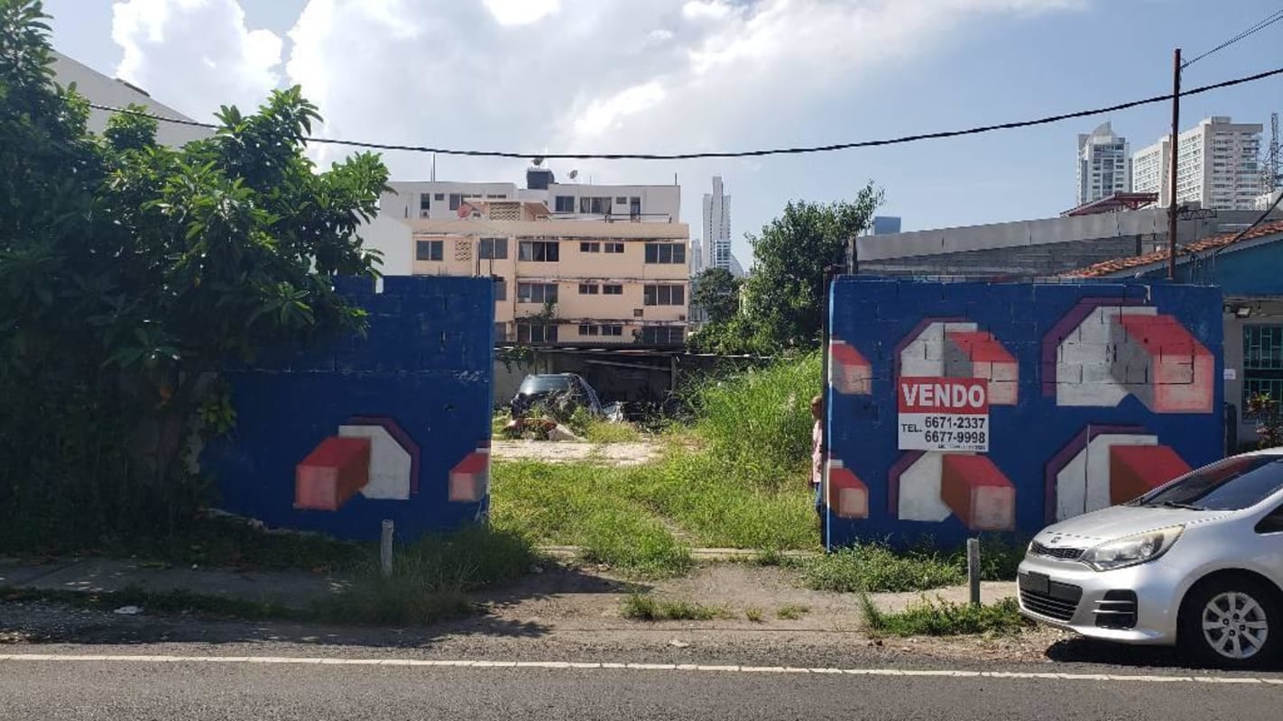 Vacant fenced lot with graffiti wall and for sale sign San Francisco Panama