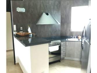 Remodeled kitchen with granite counters, stainless steel appliances, and modern cabinetry in Playa Blanca Resort condo