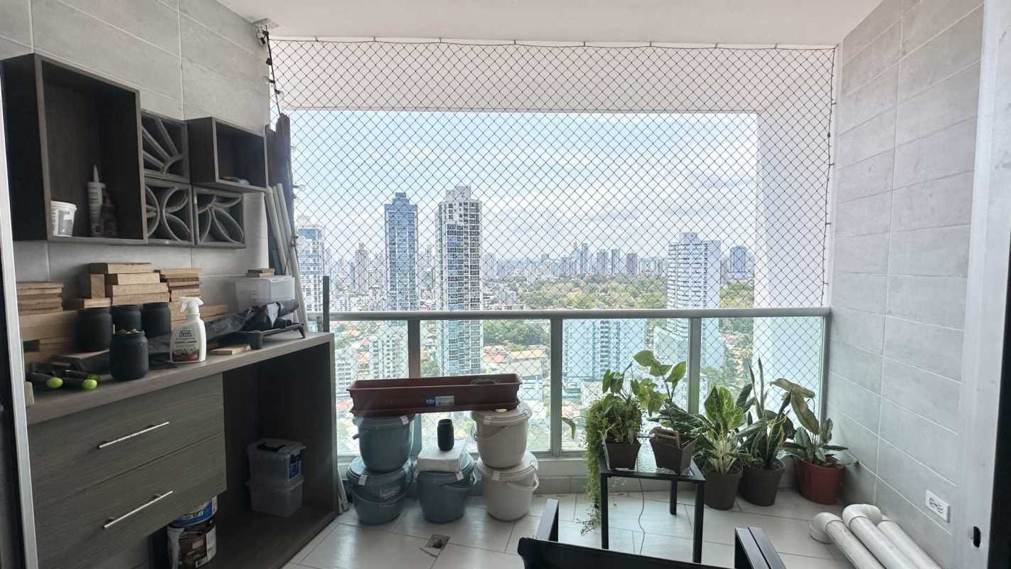 Double-height loft space with large windows, green accent wall and city view at PH Park Loft San Francisco Panama