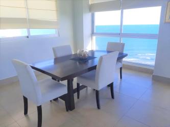 Modern dining space with large glass door to ocean balcony PH Rio Mar Beach Panama