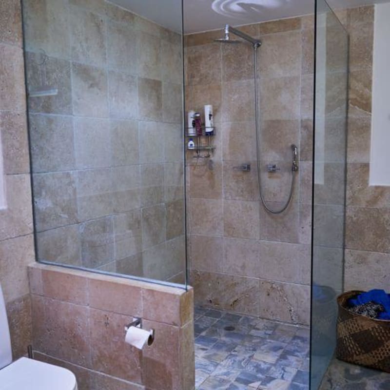 Bedroom with patterned tile floors, exposed beams, vivid decor and large window PH 4 Casas Casco Viejo Panama