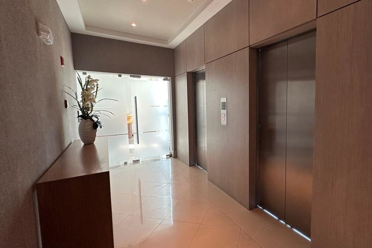 Lobby elevator area with wood paneling and flower arrangement PH Blue Business Center San Francisco Panama