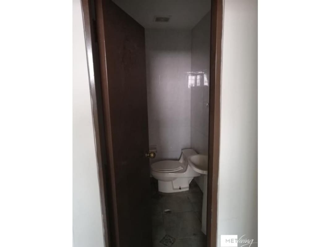 Small commercial bathroom with toilet and bidet tiled walls at PH Metric San Francisco Panama office