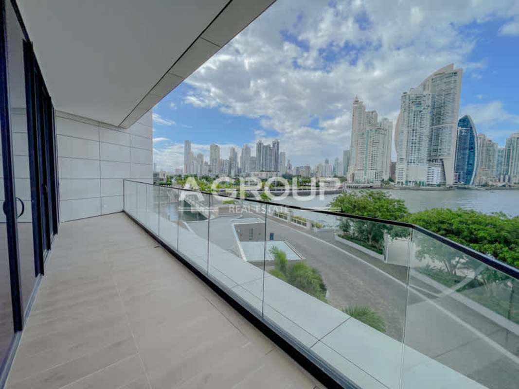 Industrial chic living room with panoramic ocean and city skyline views at Ocean Reef Islands Panama City