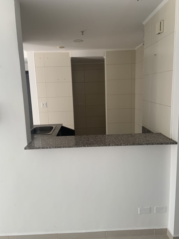 Bright open-plan living area with tiled floors and window in PH Torres del Este Panama